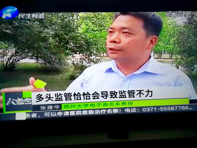 张建华教授在郑州大学新校区图书馆前，接受河南电视台民生频道大参考栏目记者采访